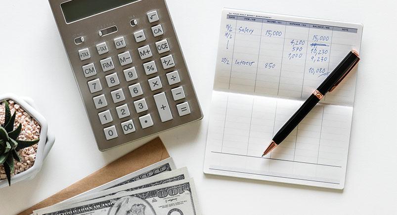 A calculator with a notepad and pen