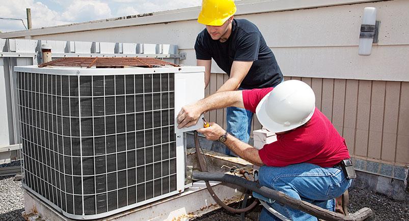 HVAC technicians fixing a heating and cooling unit