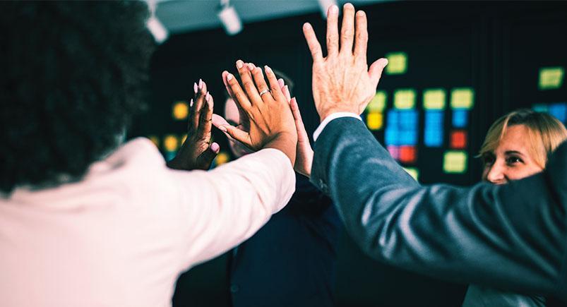 Happy employees high-fiving each other