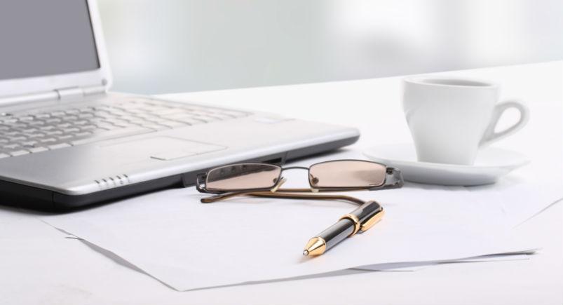 Paperwork and a laptop on a desk