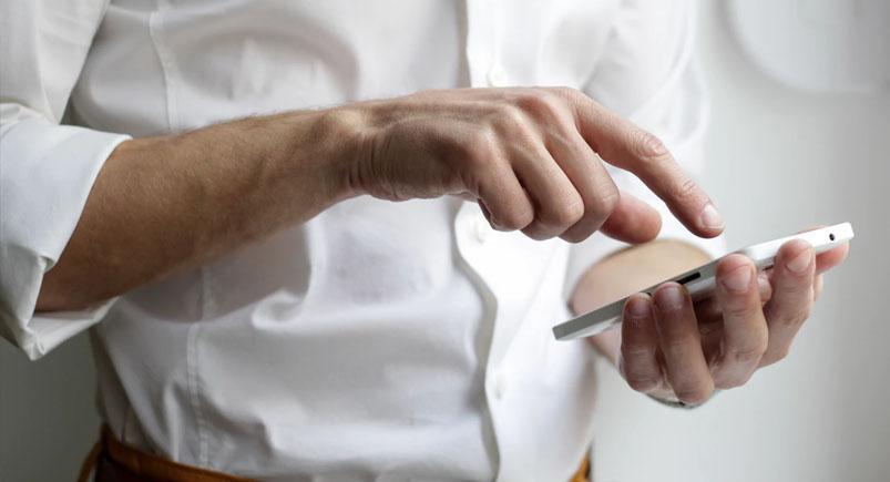 man_using_phone_feature-study-timekeeping Employee clocking in remotely