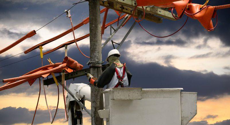 Electrical company employee repairing power line