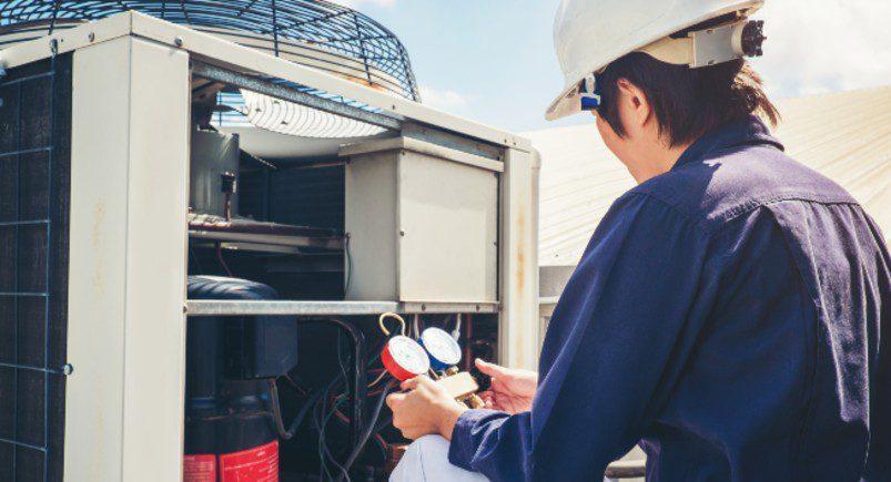 HVAC worker installing A/C unit