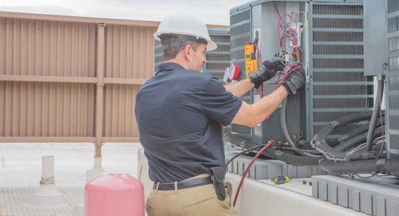 HVAC employee working on an air conditioning unit