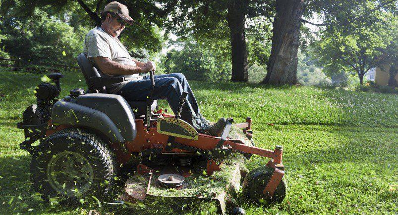 Landscaping worker mowing land