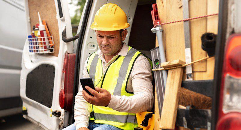 Construction contractor reviewing job details on his phone via Mobile Workforce Plus