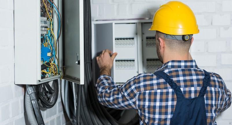 Electrician working on fuse box