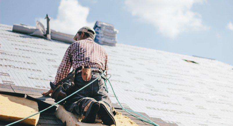 Roofer fixing shingles in a home improvement project, showing the need for an optimized workflow like that of TeamWherx