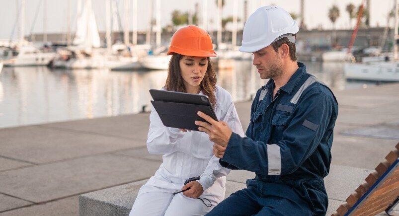 Engineers using tablet and discussing resource allocation