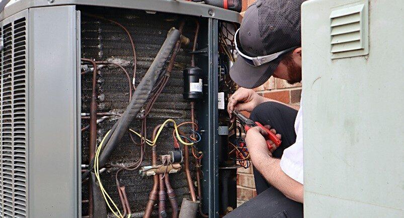 HVAC technician repairing A/C unit