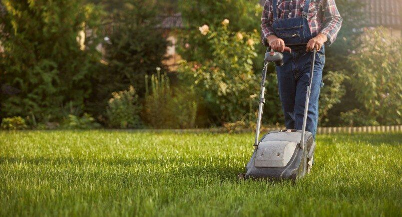 Lawn care employee mowing yard