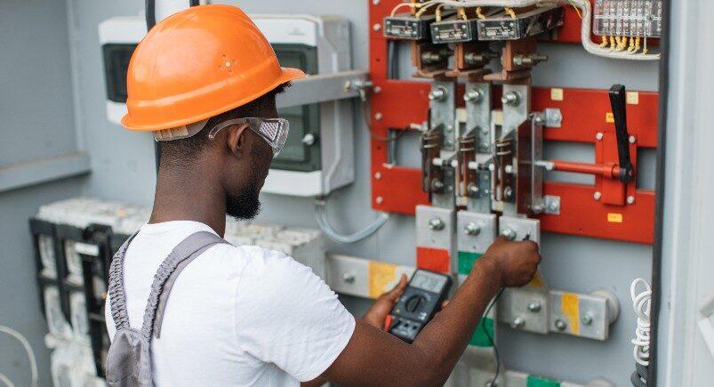 An electrician monitoring the voltage of an electrical box