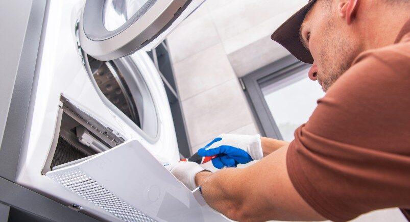 appliance-repair-specialist-fixing-a-washing-machine An appliance repair specialist fixing a washing machine