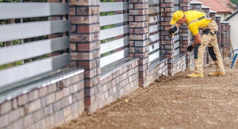 A fencing company employee installing a residential fence