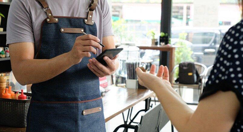 A restaurant employee using a mobile phone