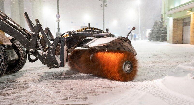 A snowplowing vehicle clearing a snowy street