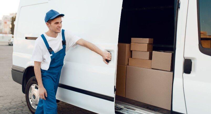 A courier service delivery driver closing a vehicle door