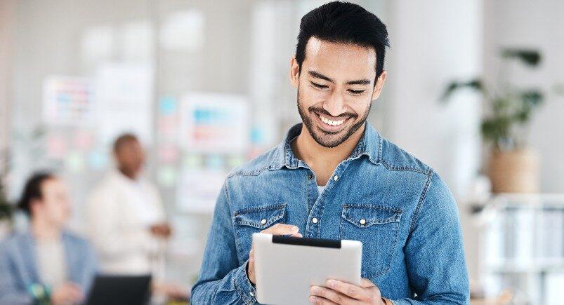 A businessman using workforce management solutions on a tablet